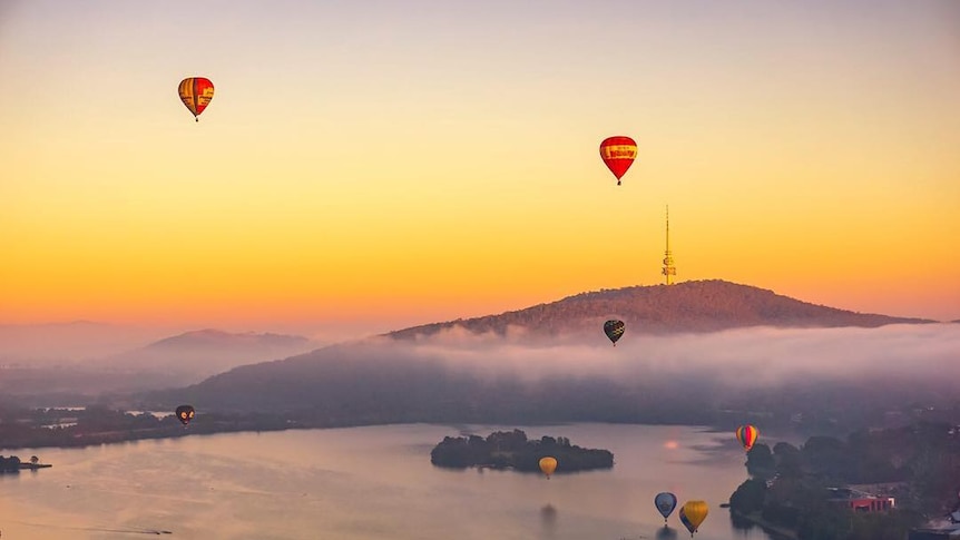 Hot air balloons rise over Lake Burley Griffin in Canberra.