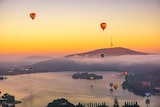 Hot air balloons rise over Lake Burley Griffin in Canberra.