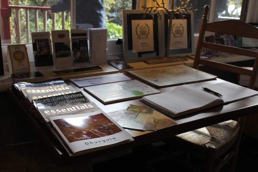 A table with a guest book and awards in a Bed and Breakfast accommodation.