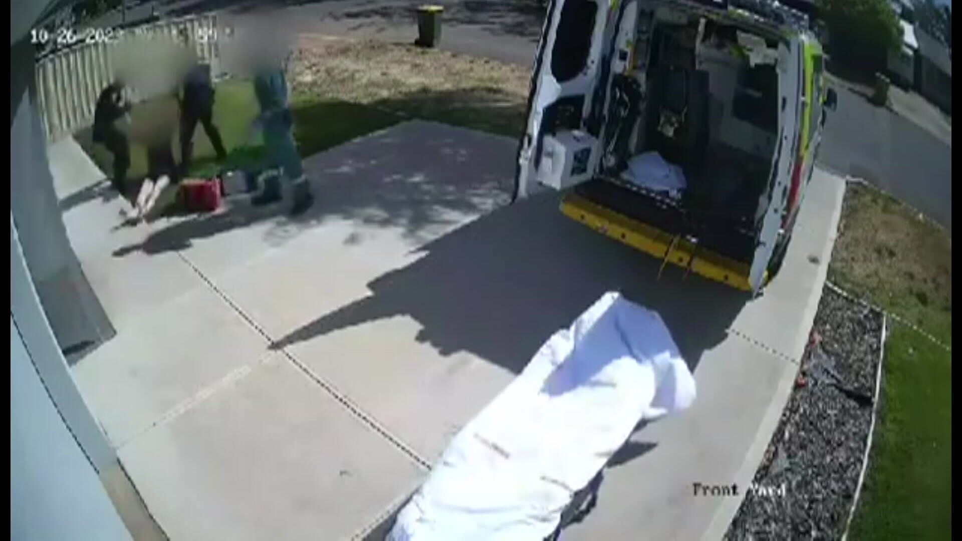 CCTV vision of two police officers standing next to a man on the ground. 