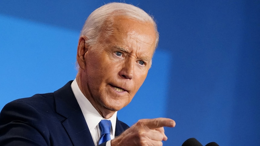 Joe Biden has a stern expression and points at something.