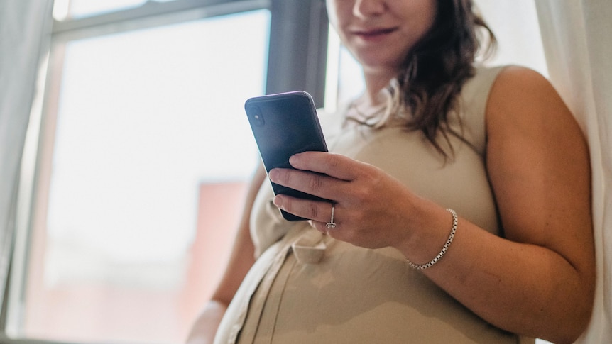 A pregnant woman using a mobile phone