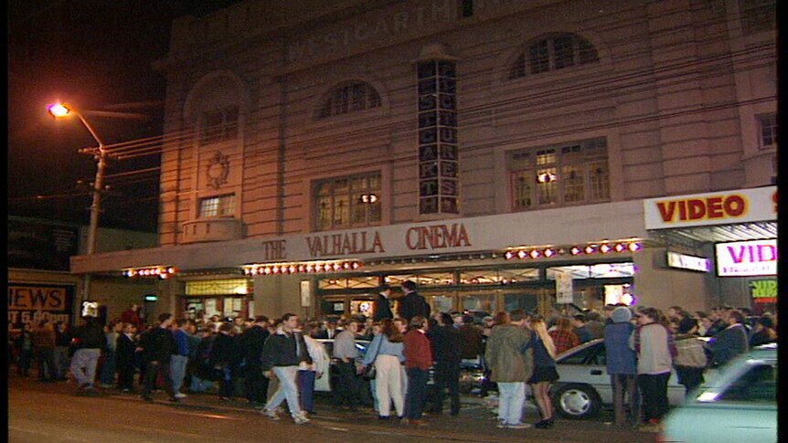 A crowd gathers on footpath outside grand cinema with 'The Valhalla Cinema' on sign