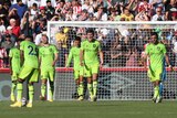 Manchester United players close their eyes or shout in frustration as they walk back to the centre circle after a goal.