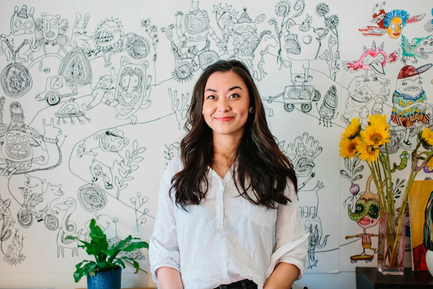 Chantal Miller smiling in front of a mural.