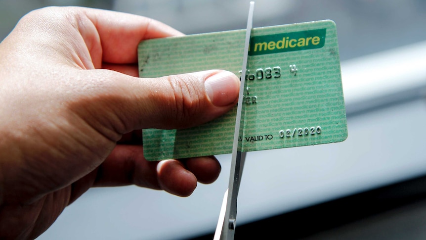 A Medicare card being cut with scissors
