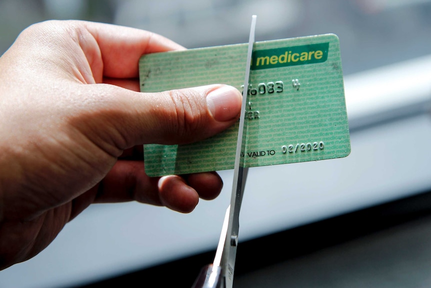 A Medicare card being cut with scissors