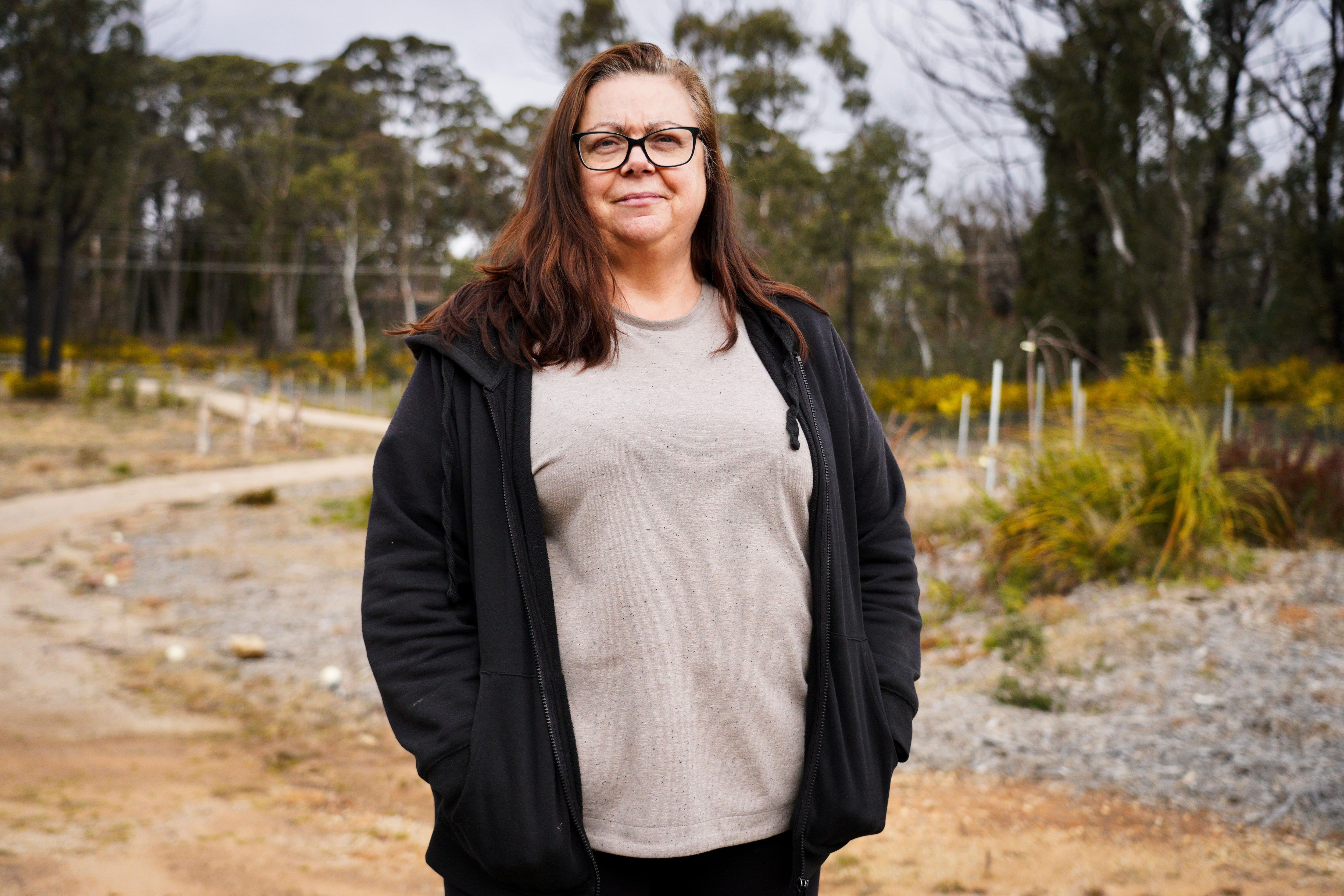 A woman in casual clothes standing on a road on her Blue Mountains property