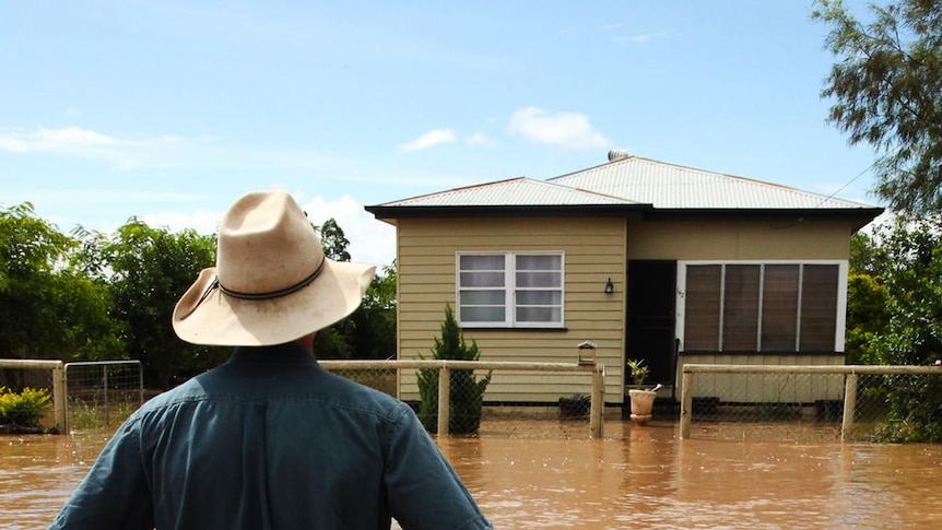 Man standing in floodwaters on street in Dalby in southern Qld in the Lockyer Valley.
