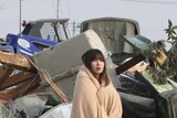 Stunned woman stands amid the debris of Japan quake