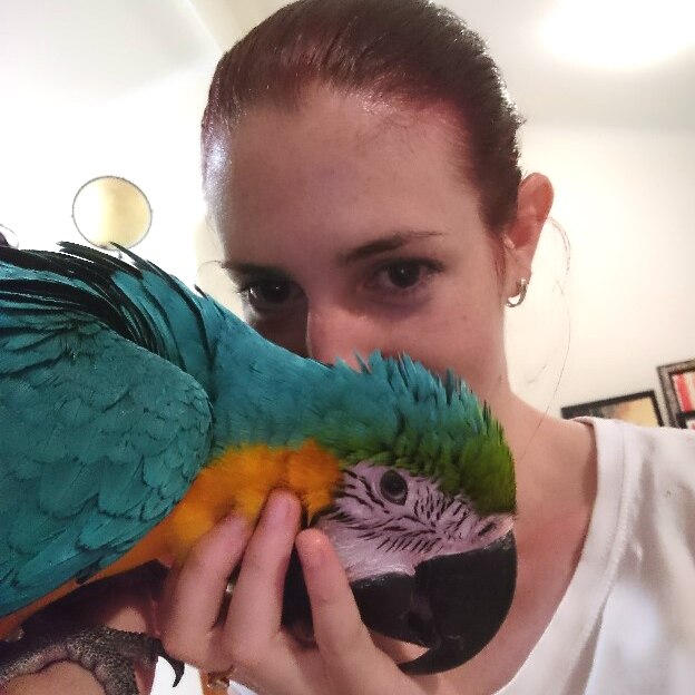 Woman stands up close with macaw