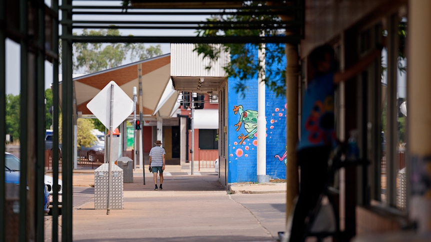 A lone man walking down a quiet street in the Katherine CBD.