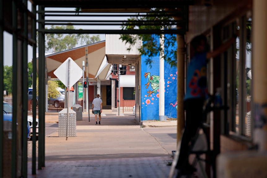 A lone man walking down a quiet street in the Katherine CBD.