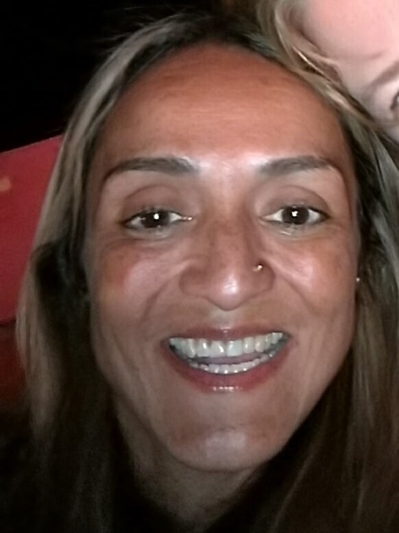 Forty-two-year-old mother of two Griselle smiling and showing her fixed tooth.