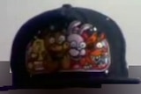 A black cap showing colourful cartoon animals embroidered into the front.