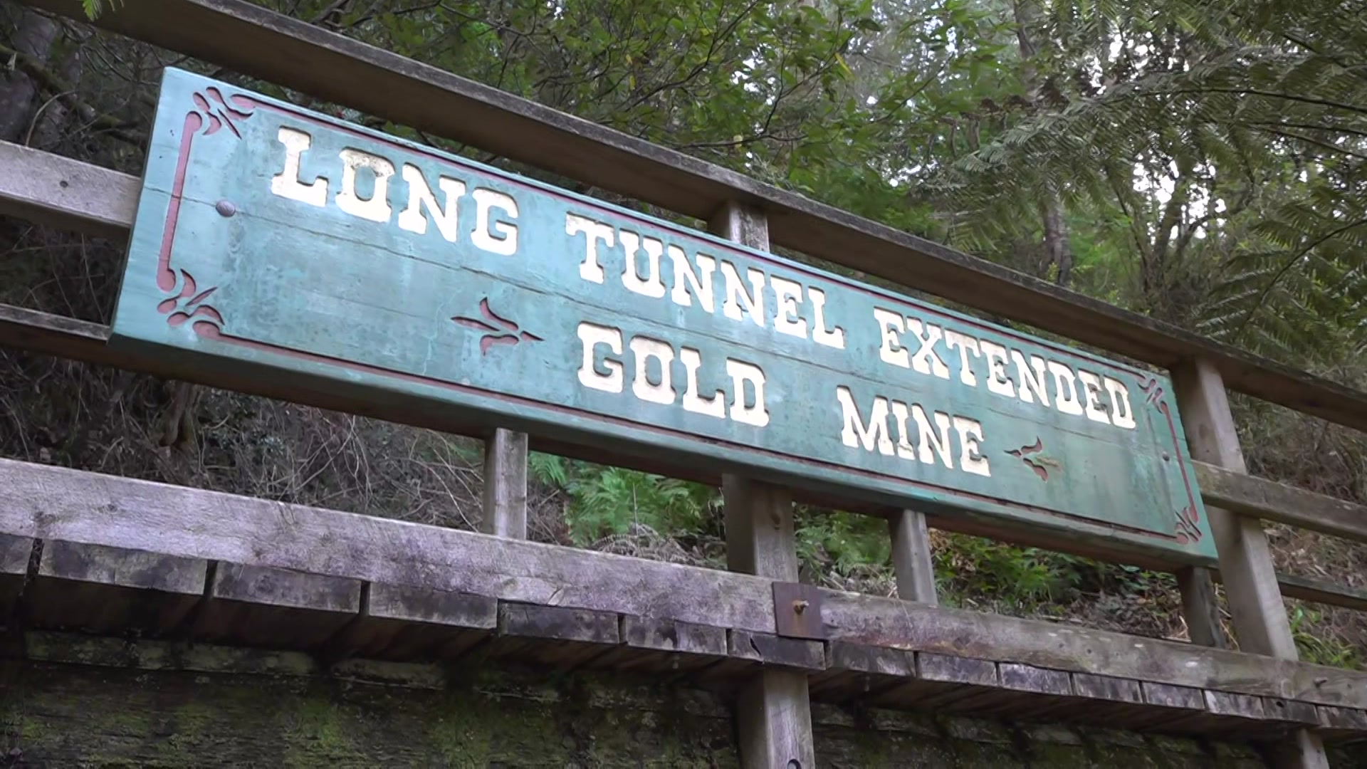A green wooden sign that says Long Tunnel Extended Gold Mine