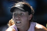An American female tennis player stretches for a backhand return at the Australian Open.