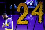 LeBron James speaks next to a floral display in the shape of Kobe Bryant's number 24.