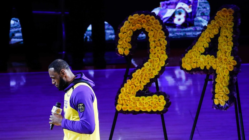 LeBron James speaks next to a floral display in the shape of Kobe Bryant's number 24.