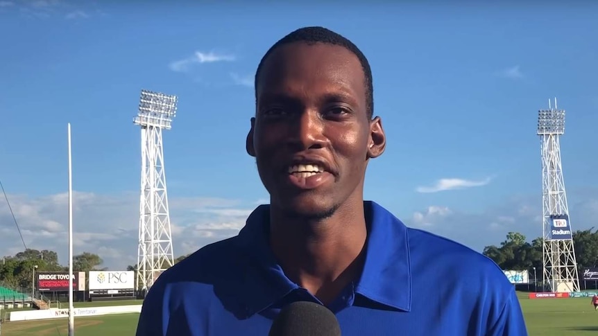 Tony Olango speaks into a microphone, in an interview posted on YouTube
