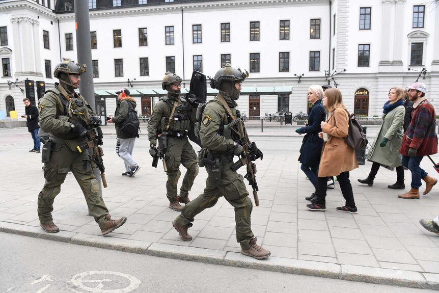 Police officers are seen outside Stockholm Central station after people were killed when a truck crashed into department store.