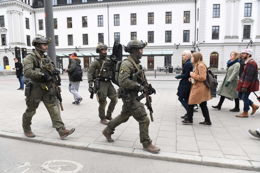 Police officers are seen outside Stockholm Central station after people were killed when a truck crashed into department store.