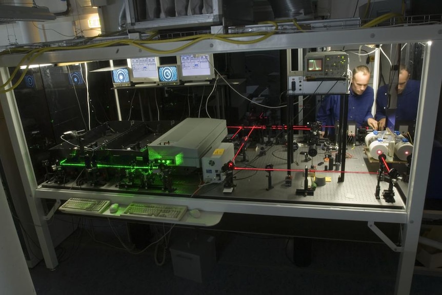 Dr Hannes Vogelmann controlling a red and a green laser, bouncing off mirrors