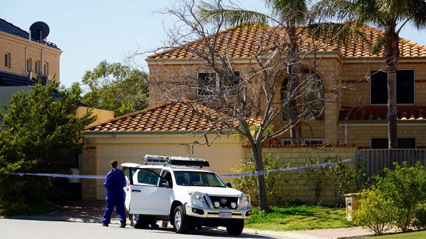 A two-storey house with police tape in front of it and a forensic detective in a blue jumpsuit.