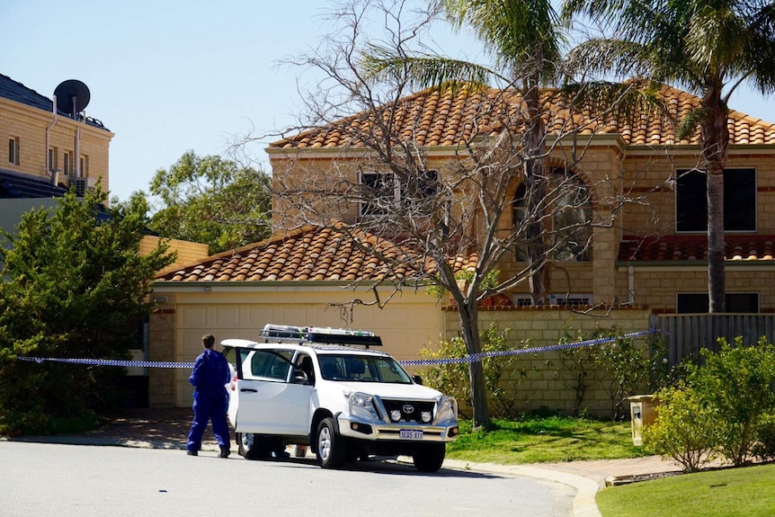 A two-storey house with police tape in front of it and a forensic detective in a blue jumpsuit.