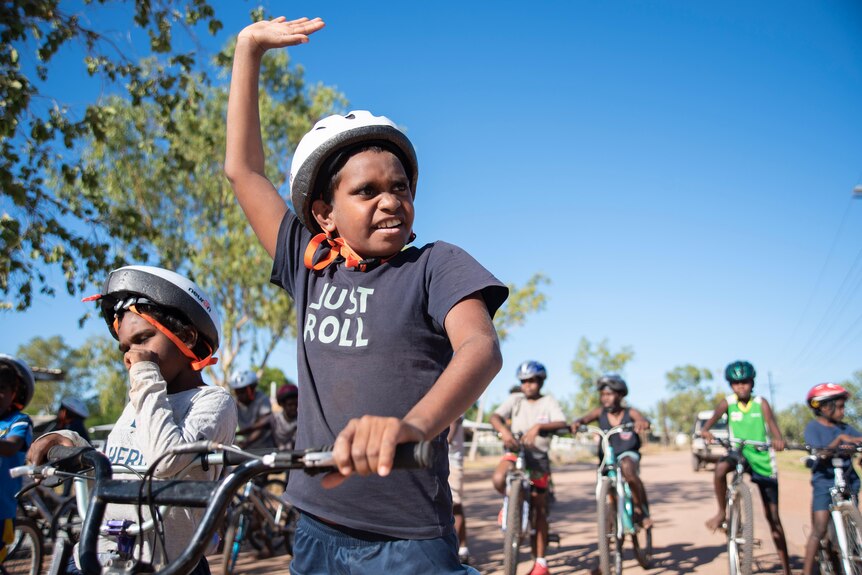 A student waves to his parents watching the race in Yarralin from the sidelines. 