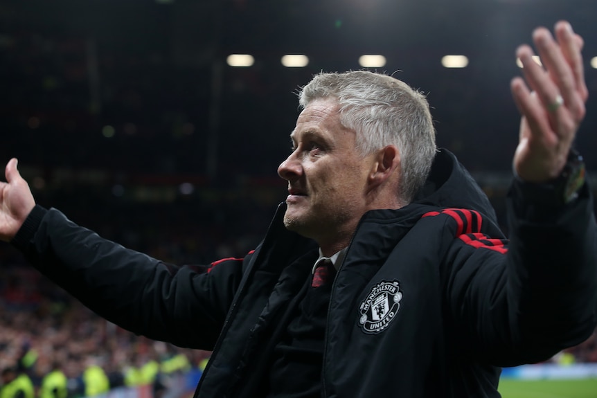Ole Gunnar Solskjaer holds his arms out and looks into the crowd