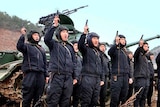 North Korean soldiers point their guns to the sky
