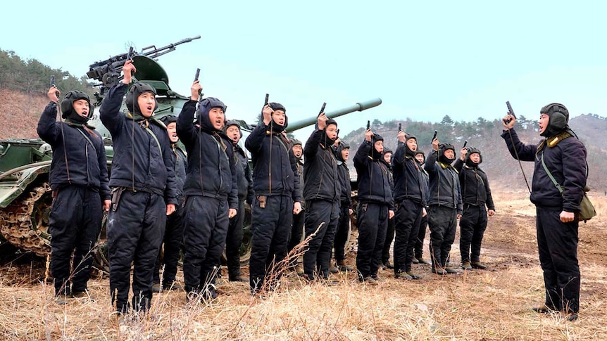 North Korean soldiers point their guns to the sky