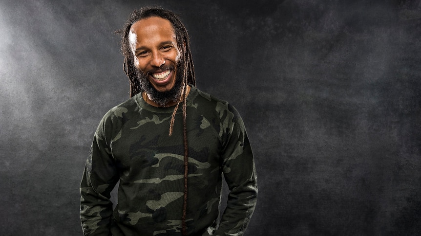 Ziggy Marley smiles as he stares into the camera