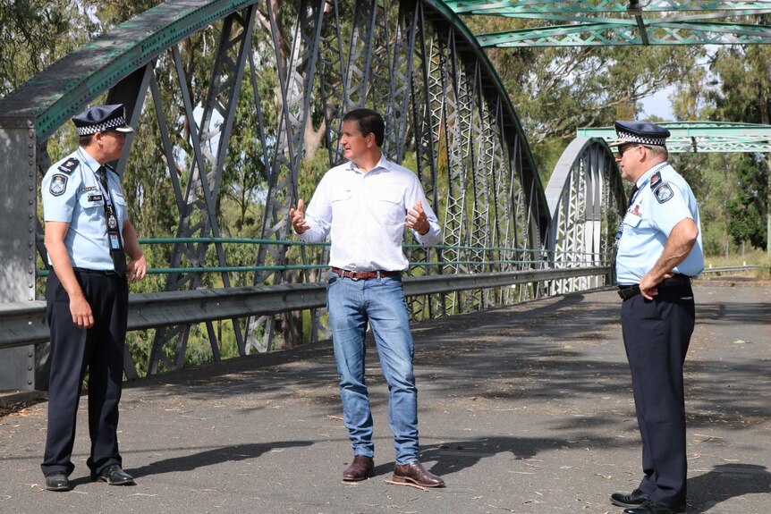 Mark Kelly, Lawrence Springborg and Mike Condon in conversation on a bridge.