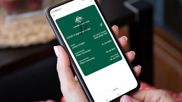 A woman holding a smartphone with the vaccine certificate