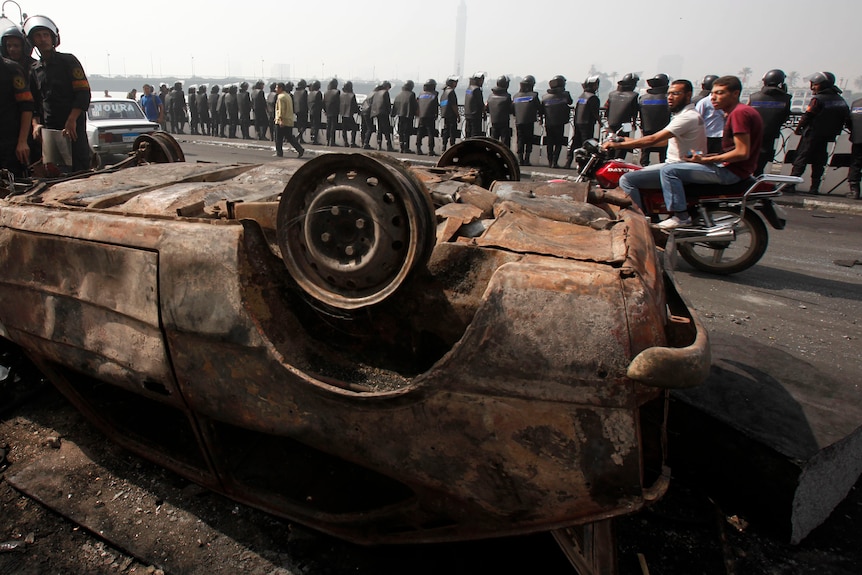 Egyptian police guard a destroyed car