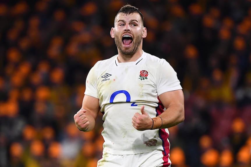 A male England rugby union player pumps his fists during Test against Australia.