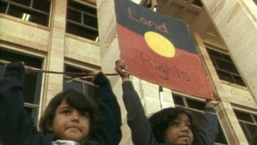 Aboriginal children hold up protest sign