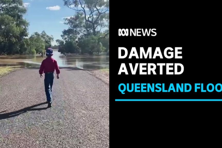 Damage Averted, Queensland Floods: A man walks down a road that has been cut-off by floodwaters.