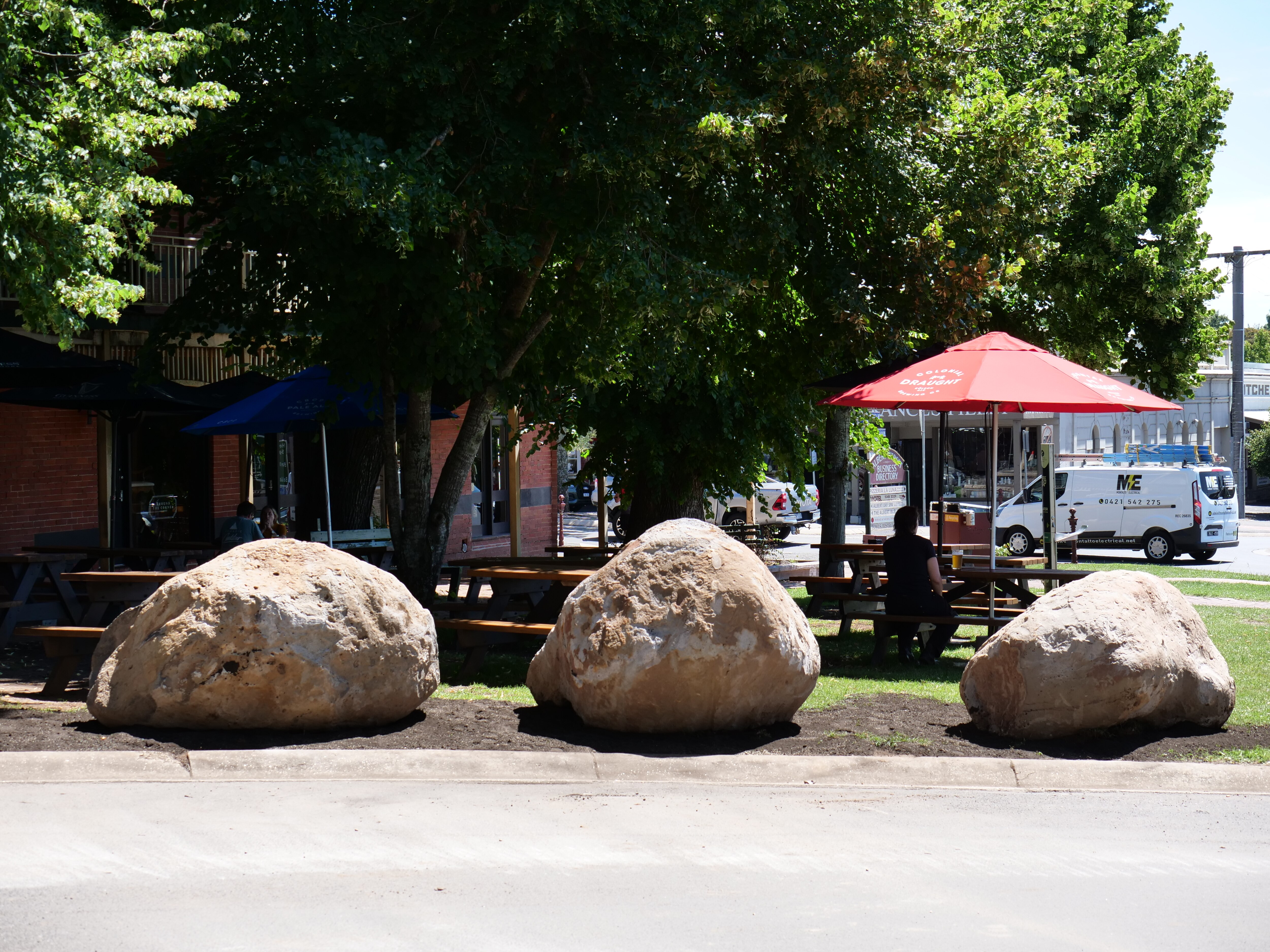 Three large rocks sit on the edge of the road