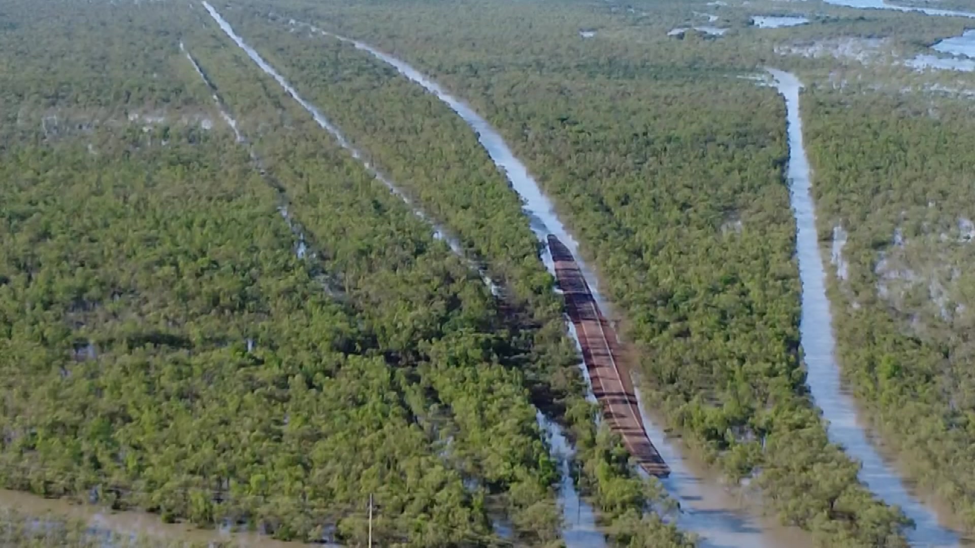 Uma foto de helicóptero de uma paisagem verde com rios inundados e riachos passando por ela