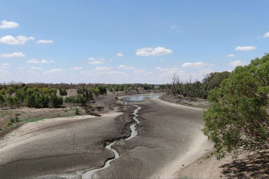 A shot of an empty, cracked riverbed taken from a drone.