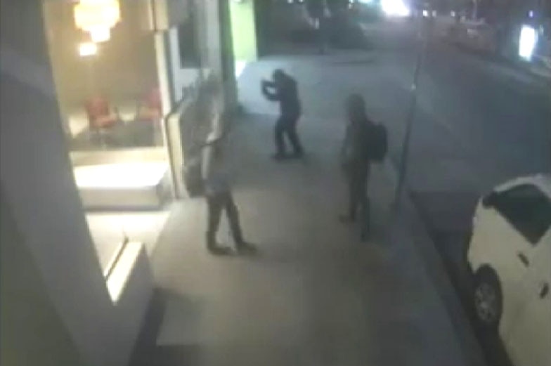 Three members of a neo-Nazi group outside the ALP's Victorian headquarters where they put up homophobic posters.