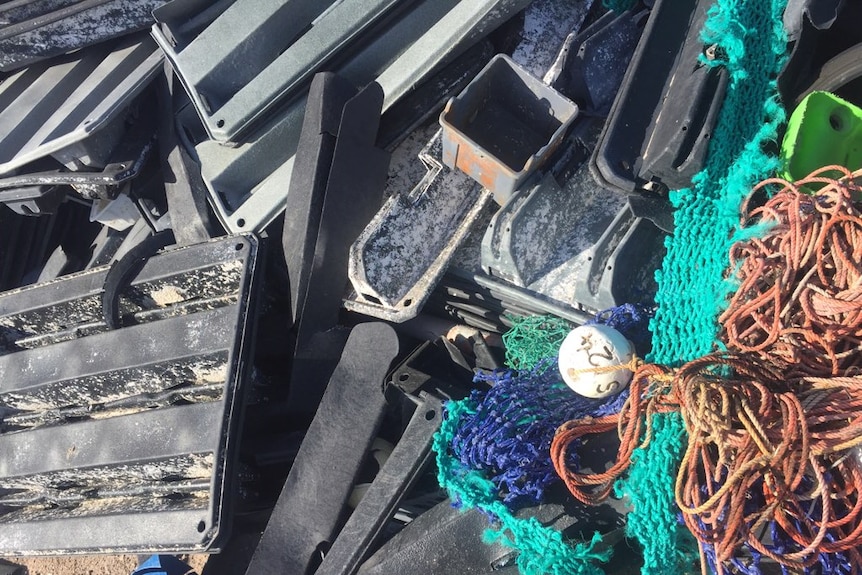 A pile of black plastic trays as long as your arm and various colours and lengths of rope in a pile