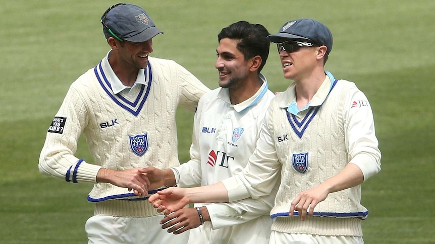 Jason Sangha (centre) is congratulated by New South Wales teammates after taking a Sheffield Shield wicket.