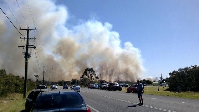 Cars are being stopped along Lemon Tree Passage Road because of smoke from a bushfire at Salt Ash.