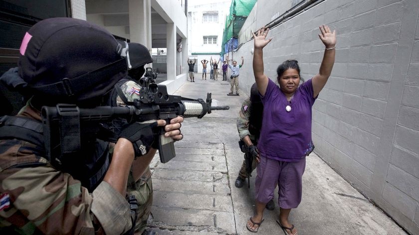 An anti-government Red Shirt supporter surrenders to army soldiers