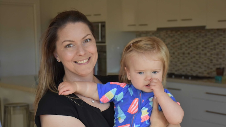 Caroline Crlenjak and her one-year-old daughter Xanthe in a house.