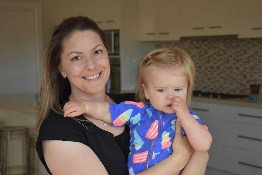 Caroline Crlenjak and her one-year-old daughter Xanthe in a house.